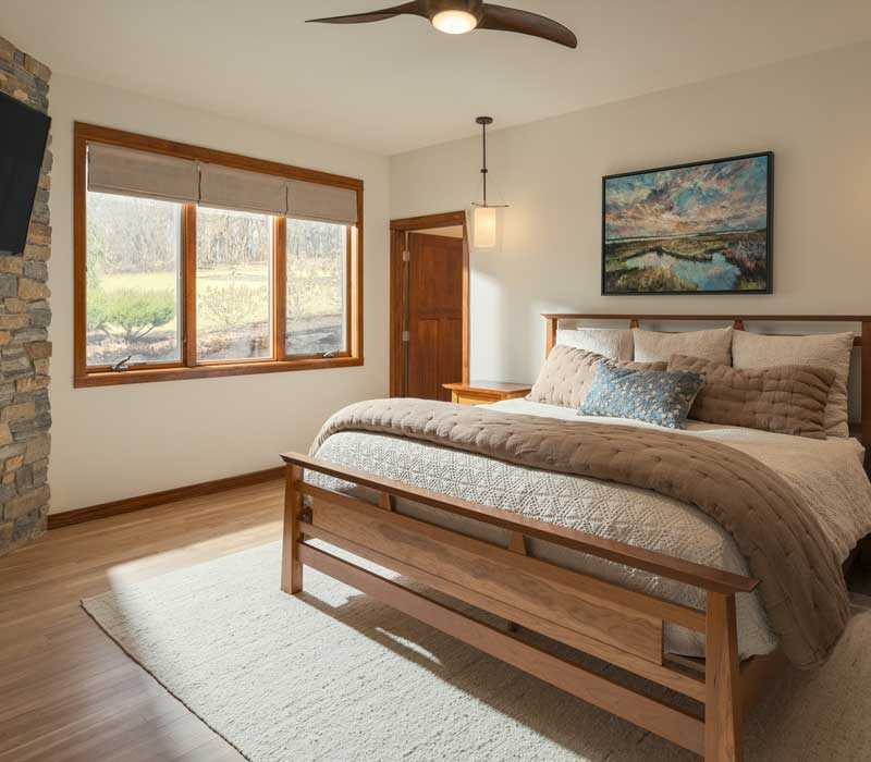 This whole-house remodel features a prairie-style kitchen adorned with custom cabinetry by DHDK, a primary suite with custom alder armoire, and bathroom with iridescent blue-green tiles.