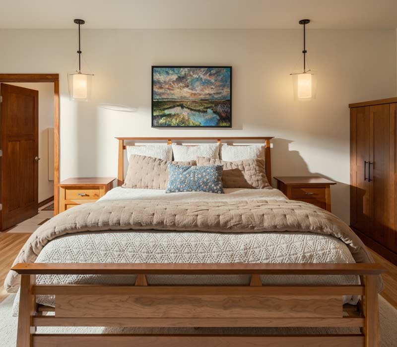This whole-house remodel features a prairie-style kitchen adorned with custom cabinetry by DHDK, a primary suite with custom alder armoire, and bathroom with iridescent blue-green tiles.