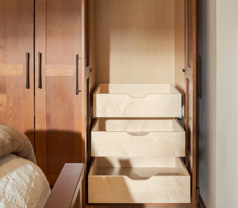 This whole-house remodel features a prairie-style kitchen adorned with custom cabinetry by DHDK, a primary suite with custom alder armoire, and bathroom with iridescent blue-green tiles.