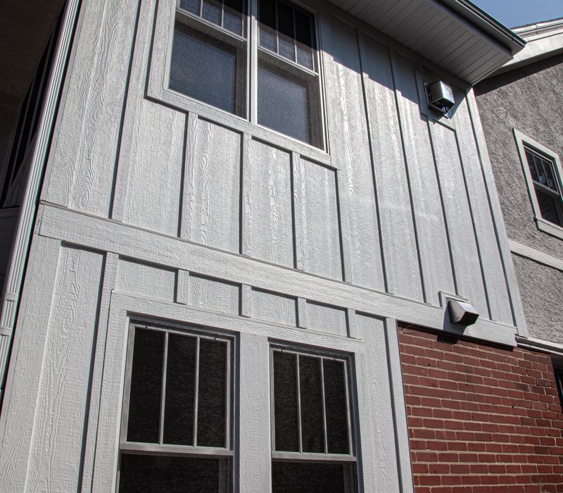 Dark woodwork, patterned terra cotta tile floors, and exposed brick interior walls define the kitchen and addition of this Craftsman home.