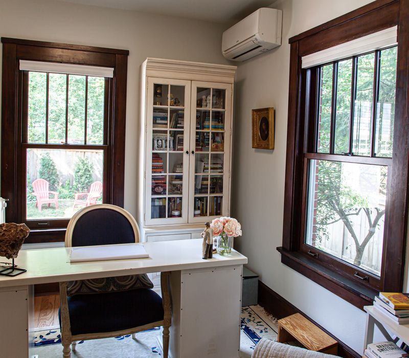 Dark woodwork, patterned terra cotta tile floors, and exposed brick interior walls define the kitchen and addition of this Craftsman home.