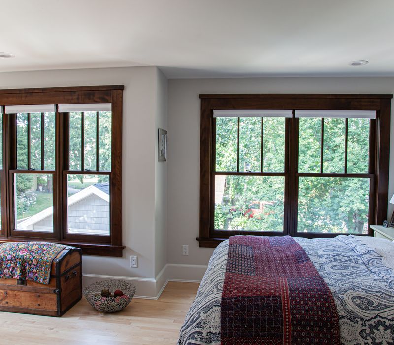 Dark woodwork, patterned terra cotta tile floors, and exposed brick interior walls define the kitchen and addition of this Craftsman home.