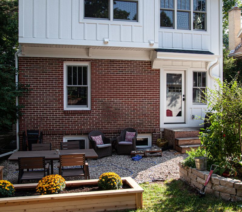 Dark woodwork, patterned terra cotta tile floors, and exposed brick interior walls define the kitchen and addition of this Craftsman home.
