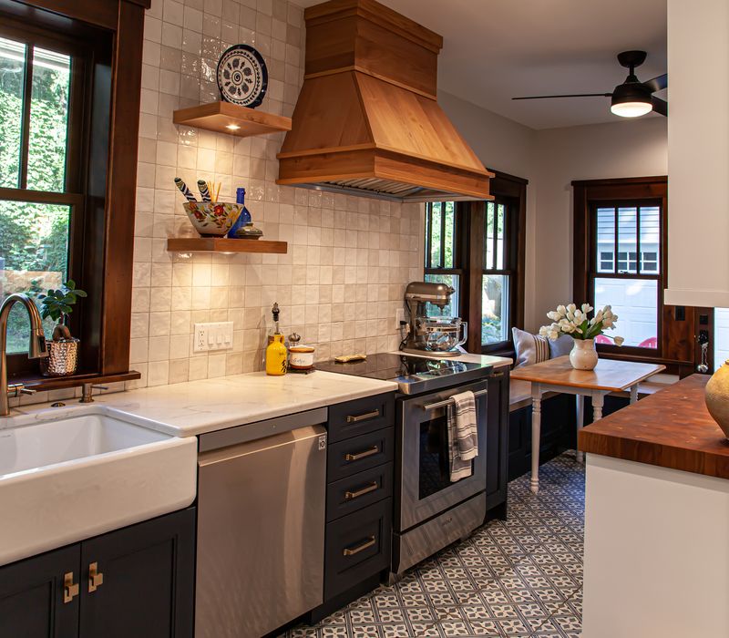 Dark woodwork, patterned terra cotta tile floors, and exposed brick interior walls define the kitchen and addition of this Craftsman home.