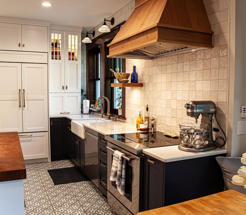 Dark woodwork, patterned terra cotta tile floors, and exposed brick interior walls define the kitchen and addition of this Craftsman home.