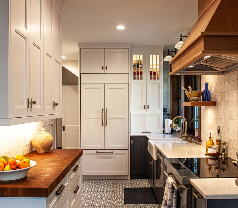 Dark woodwork, patterned terra cotta tile floors, and exposed brick interior walls define the kitchen and addition of this Craftsman home.