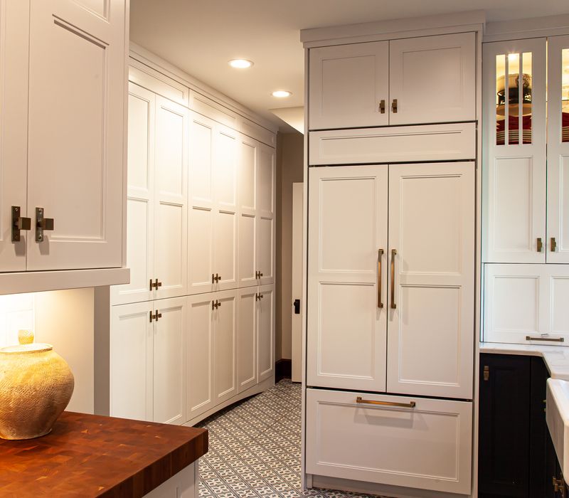 Dark woodwork, patterned terra cotta tile floors, and exposed brick interior walls define the kitchen and addition of this Craftsman home.