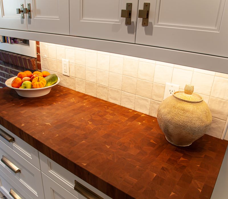 Dark woodwork, patterned terra cotta tile floors, and exposed brick interior walls define the kitchen and addition of this Craftsman home.