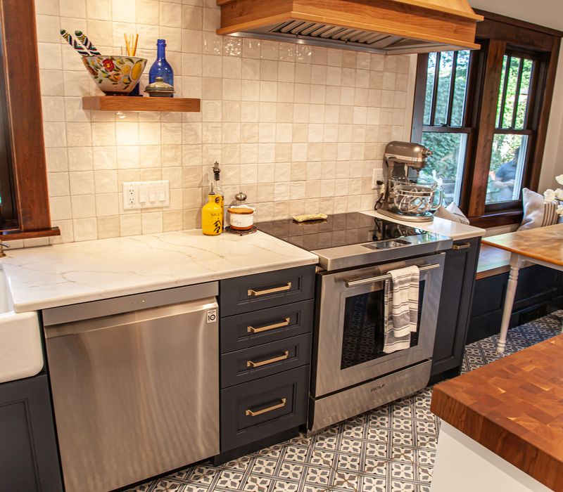 Dark woodwork, patterned terra cotta tile floors, and exposed brick interior walls define the kitchen and addition of this Craftsman home.