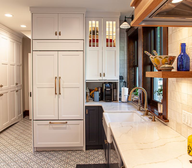 Dark woodwork, patterned terra cotta tile floors, and exposed brick interior walls define the kitchen and addition of this Craftsman home.
