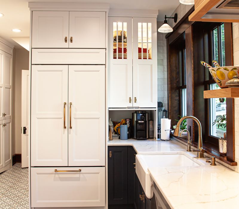 Dark woodwork, patterned terra cotta tile floors, and exposed brick interior walls define the kitchen and addition of this Craftsman home.