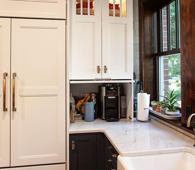 Dark woodwork, patterned terra cotta tile floors, and exposed brick interior walls define the kitchen and addition of this Craftsman home.