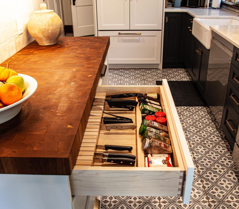 Dark woodwork, patterned terra cotta tile floors, and exposed brick interior walls define the kitchen and addition of this Craftsman home.