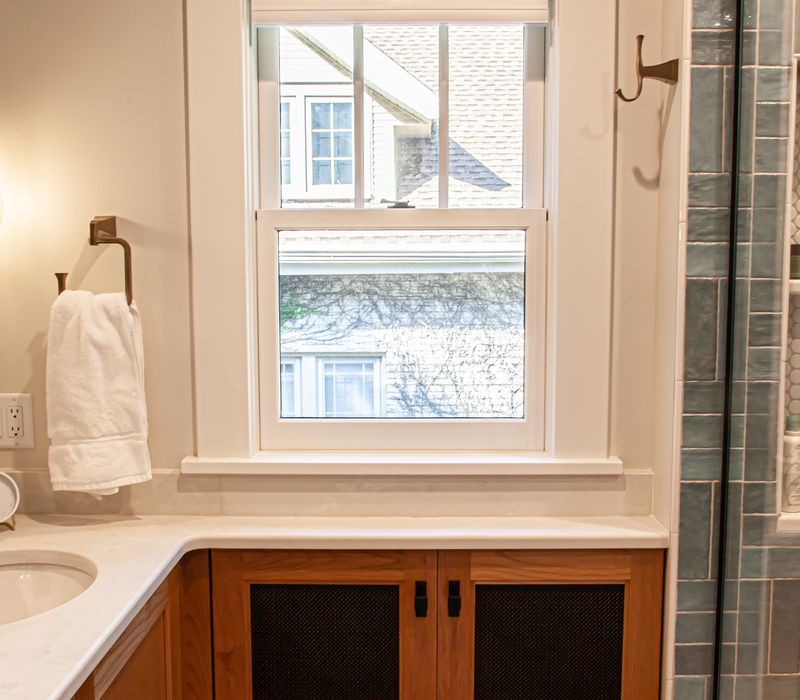 Dark woodwork, patterned terra cotta tile floors, and exposed brick interior walls define the kitchen and addition of this Craftsman home.