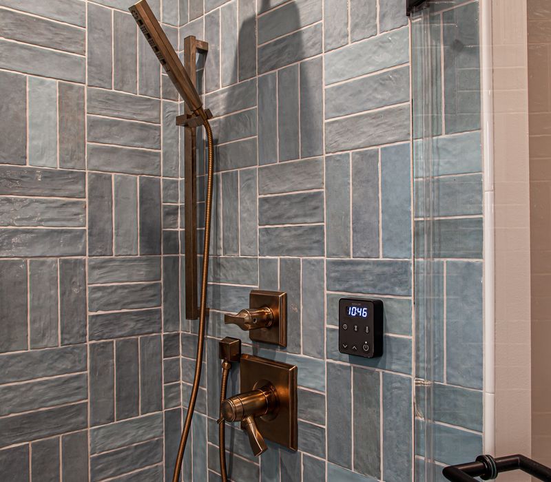 Dark woodwork, patterned terra cotta tile floors, and exposed brick interior walls define the kitchen and addition of this Craftsman home.