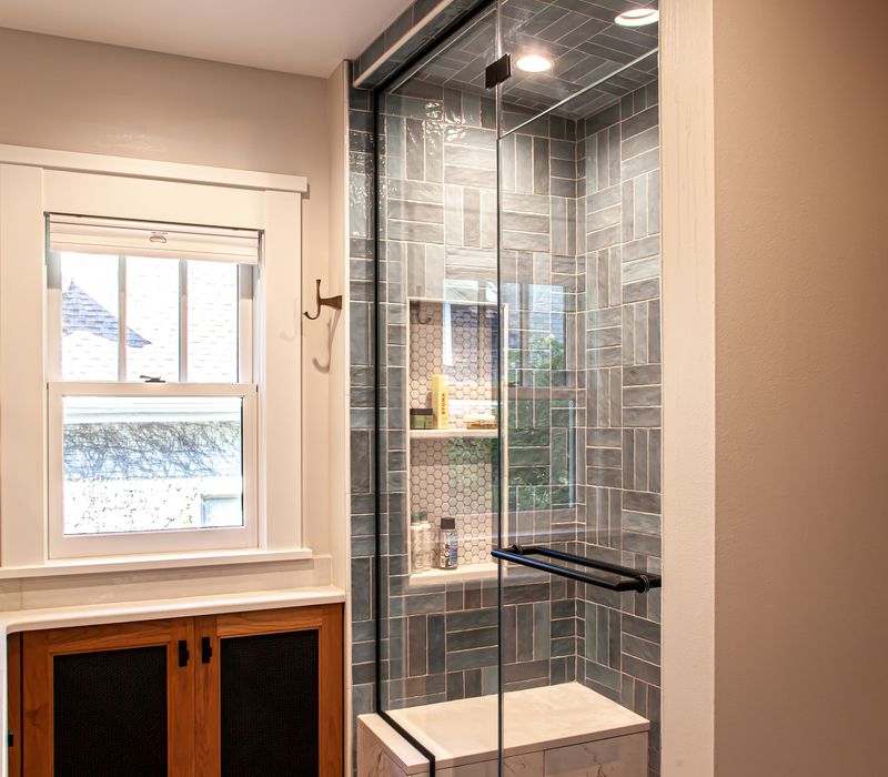 Dark woodwork, patterned terra cotta tile floors, and exposed brick interior walls define the kitchen and addition of this Craftsman home.