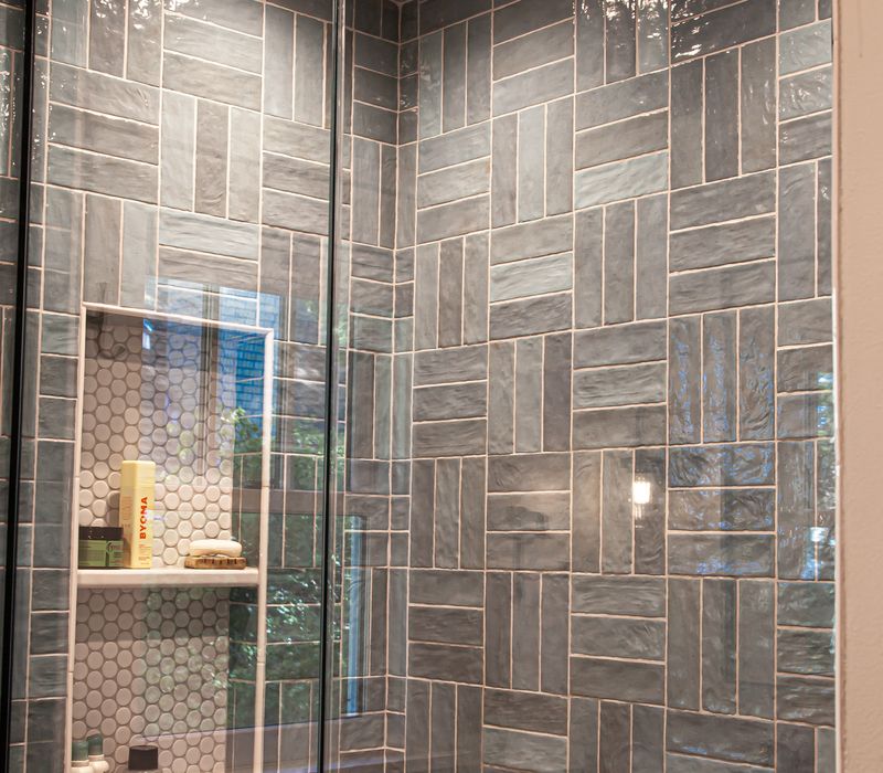 Dark woodwork, patterned terra cotta tile floors, and exposed brick interior walls define the kitchen and addition of this Craftsman home.