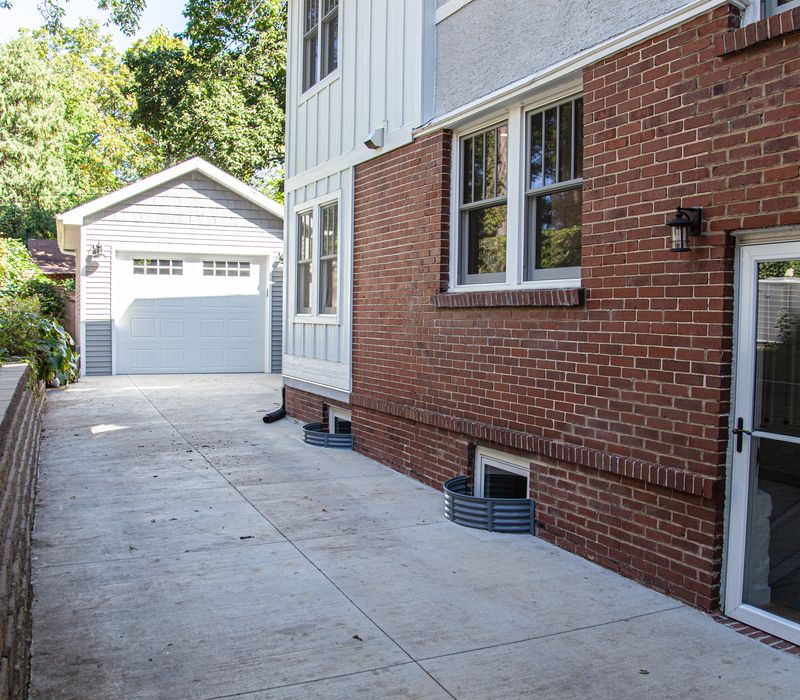 Dark woodwork, patterned terra cotta tile floors, and exposed brick interior walls define the kitchen and addition of this Craftsman home.