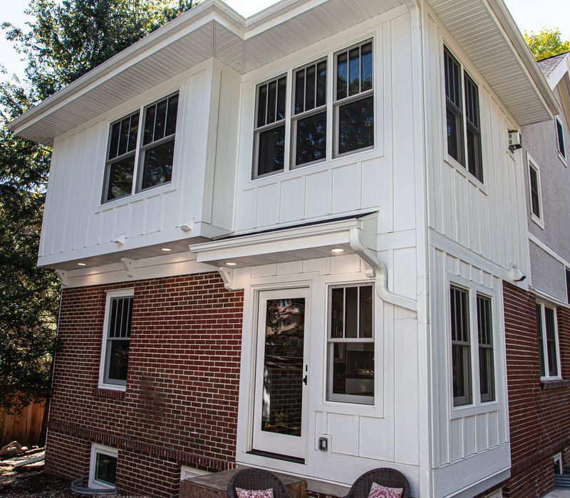 Dark woodwork, patterned terra cotta tile floors, and exposed brick interior walls define the kitchen and addition of this Craftsman home.
