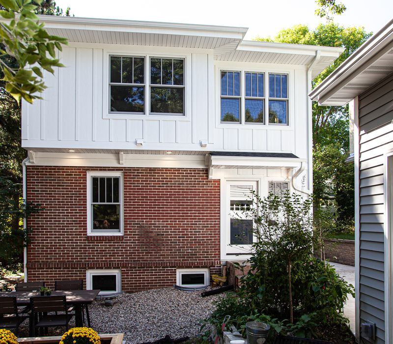 Dark woodwork, patterned terra cotta tile floors, and exposed brick interior walls define the kitchen and addition of this Craftsman home.