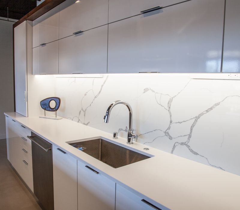 White and stainless steel dominate in this minimalist condo showcasing contemporary artwork. 