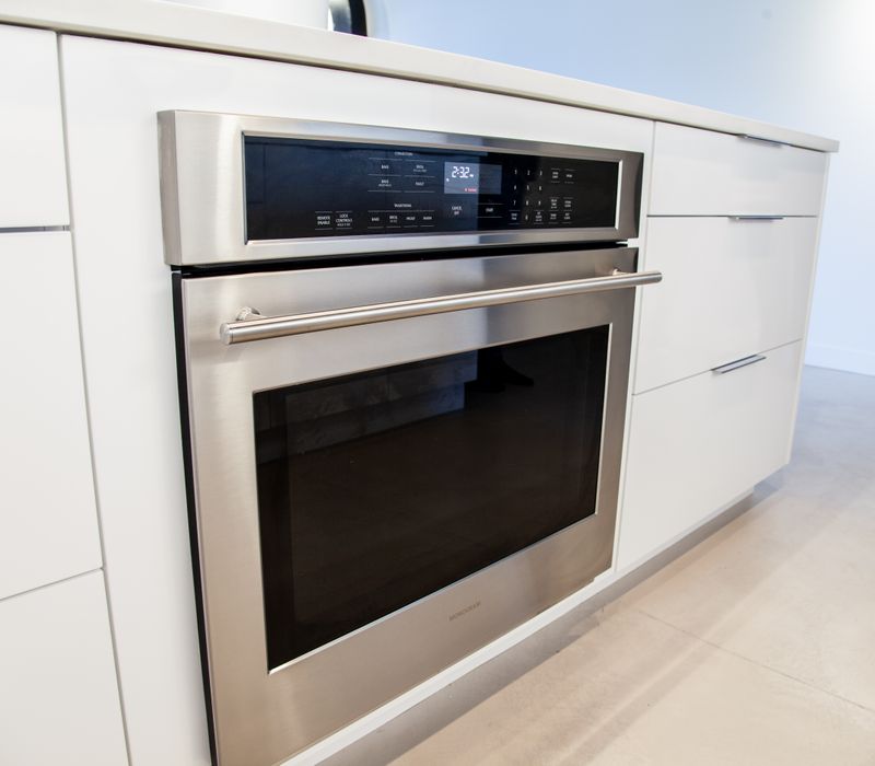 White and stainless steel dominate in this minimalist condo showcasing contemporary artwork. 