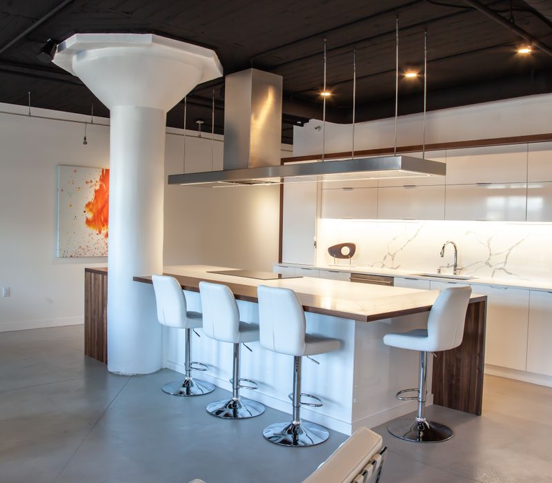 White and stainless steel dominate in this minimalist condo showcasing contemporary artwork. 