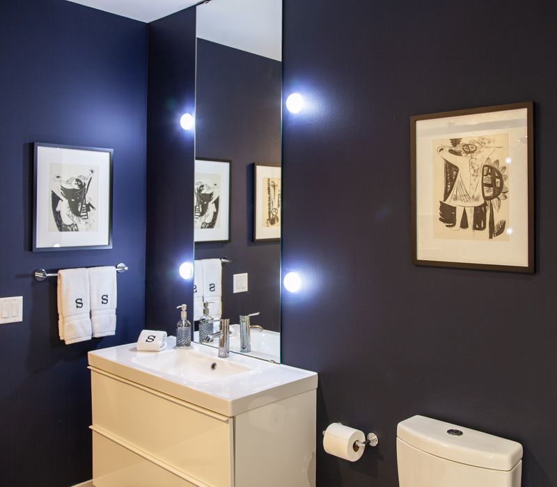 White and stainless steel dominate in this minimalist condo showcasing contemporary artwork. 