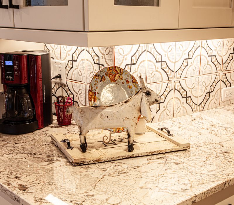 This country home has a rustic chic style with rough-hewn exposed wood beams, hand-painted terra cotta tiles, and a stone turret.