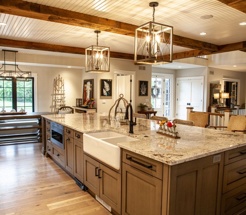 This country home has a rustic chic style with rough-hewn exposed wood beams, hand-painted terra cotta tiles, and a stone turret.
