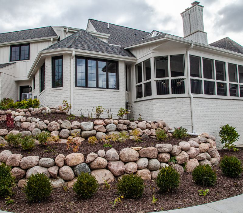 This country home has a rustic chic style with rough-hewn exposed wood beams, hand-painted terra cotta tiles, and a stone turret.