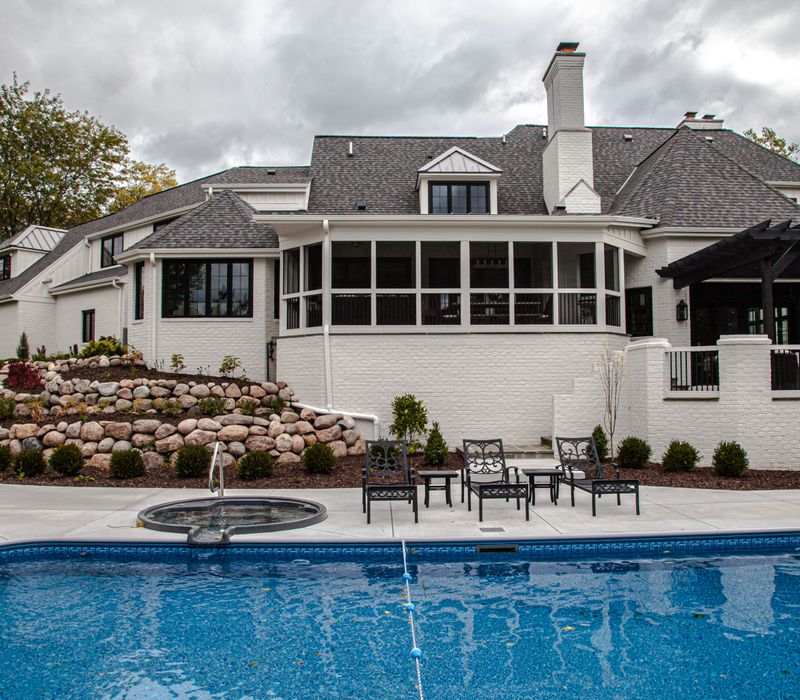 This country home has a rustic chic style with rough-hewn exposed wood beams, hand-painted terra cotta tiles, and a stone turret.