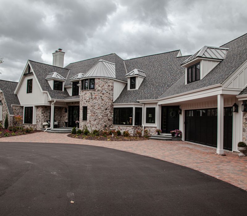 This country home has a rustic chic style with rough-hewn exposed wood beams, hand-painted terra cotta tiles, and a stone turret.