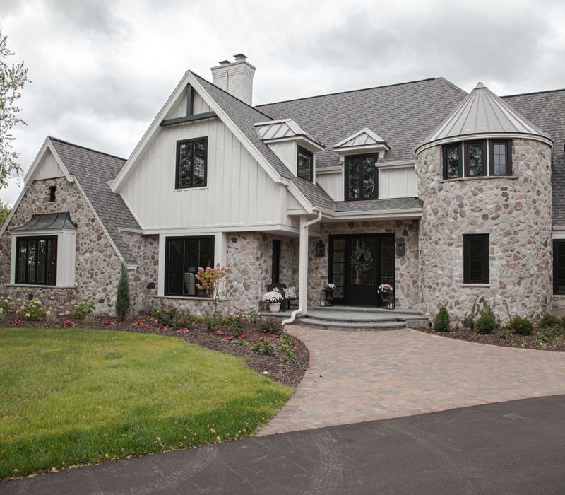 This country home has a rustic chic style with rough-hewn exposed wood beams, hand-painted terra cotta tiles, and a stone turret.