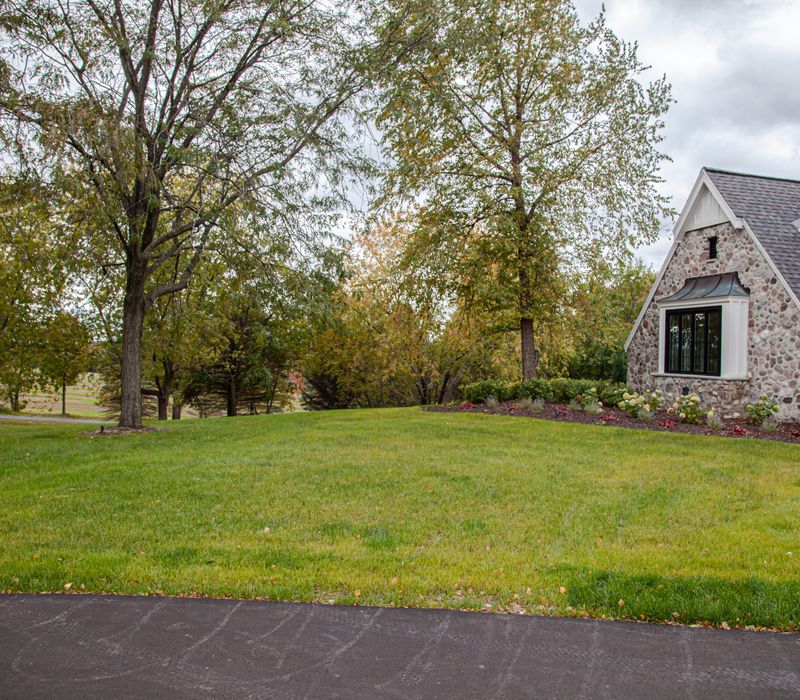This country home has a rustic chic style with rough-hewn exposed wood beams, hand-painted terra cotta tiles, and a stone turret.