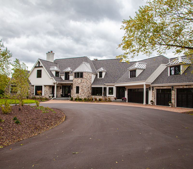 This country home has a rustic chic style with rough-hewn exposed wood beams, hand-painted terra cotta tiles, and a stone turret.