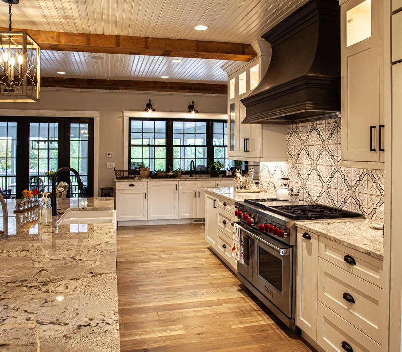 This country home has a rustic chic style with rough-hewn exposed wood beams, hand-painted terra cotta tiles, and a stone turret.