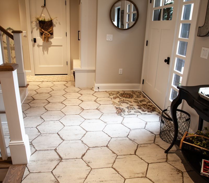 This country home has a rustic chic style with rough-hewn exposed wood beams, hand-painted terra cotta tiles, and a stone turret.