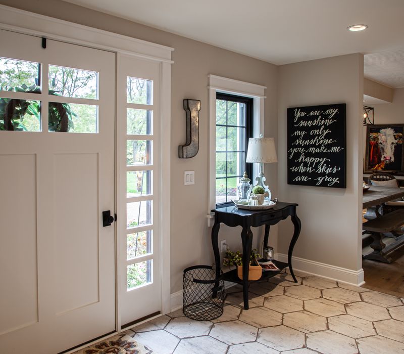 This country home has a rustic chic style with rough-hewn exposed wood beams, hand-painted terra cotta tiles, and a stone turret.