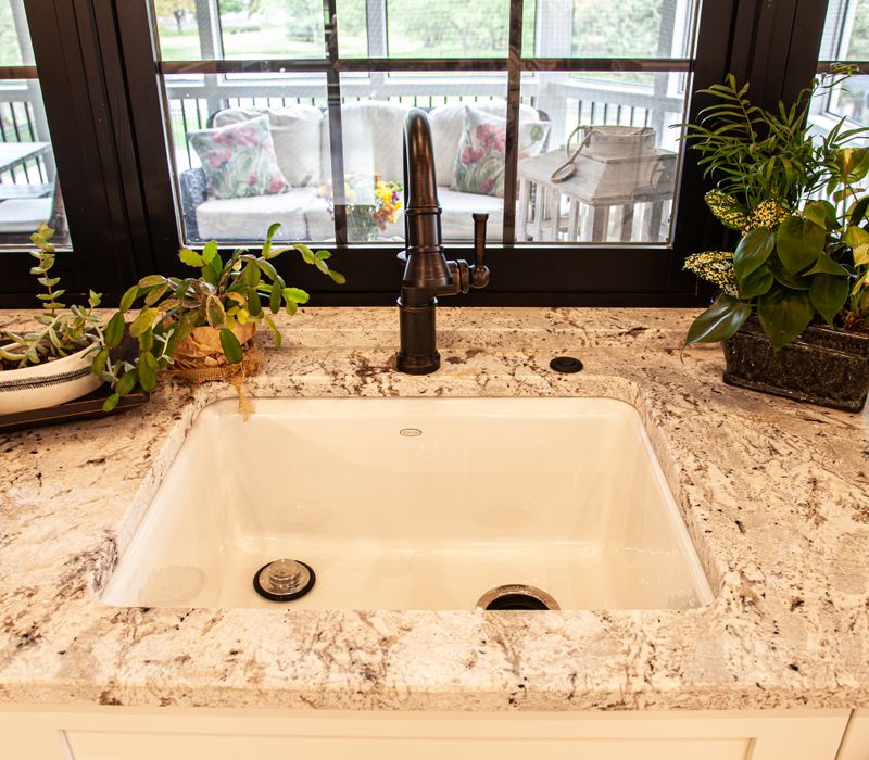 This country home has a rustic chic style with rough-hewn exposed wood beams, hand-painted terra cotta tiles, and a stone turret.