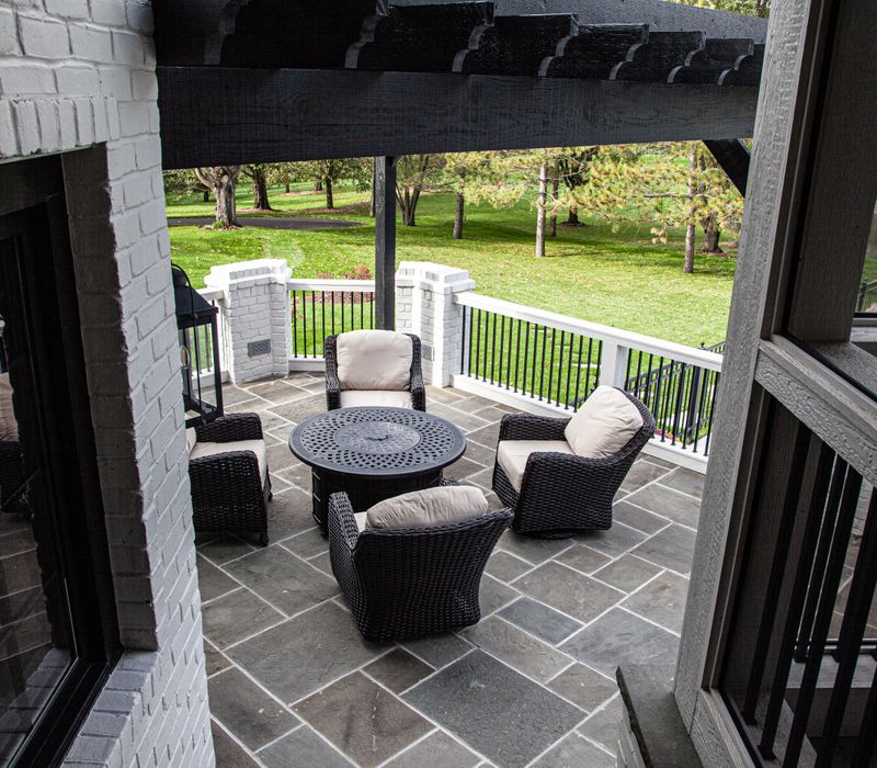 This country home has a rustic chic style with rough-hewn exposed wood beams, hand-painted terra cotta tiles, and a stone turret.
