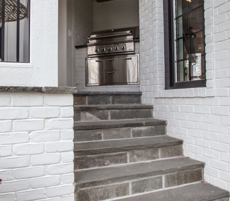 This country home has a rustic chic style with rough-hewn exposed wood beams, hand-painted terra cotta tiles, and a stone turret.