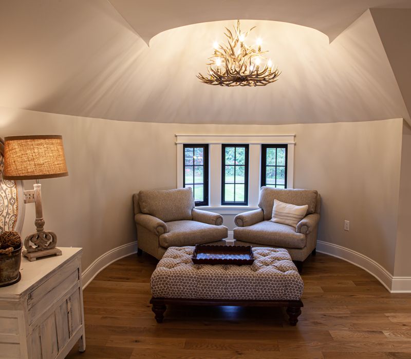 This country home has a rustic chic style with rough-hewn exposed wood beams, hand-painted terra cotta tiles, and a stone turret.