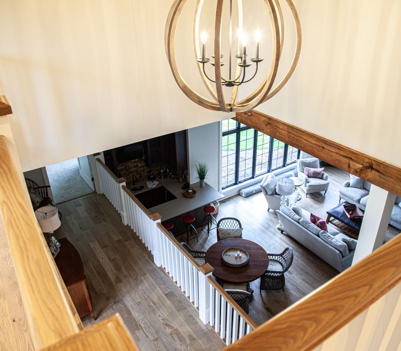 This country home has a rustic chic style with rough-hewn exposed wood beams, hand-painted terra cotta tiles, and a stone turret.