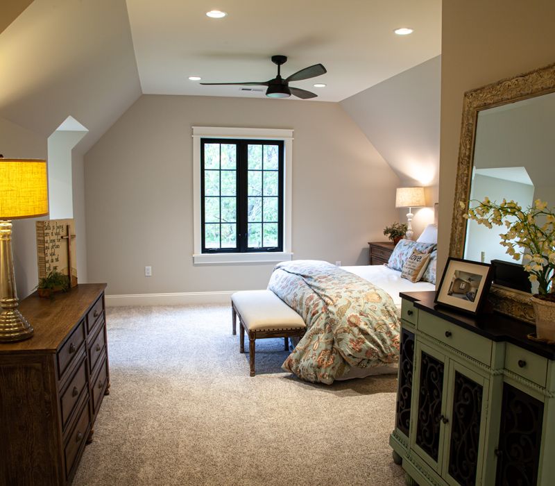 This country home has a rustic chic style with rough-hewn exposed wood beams, hand-painted terra cotta tiles, and a stone turret.