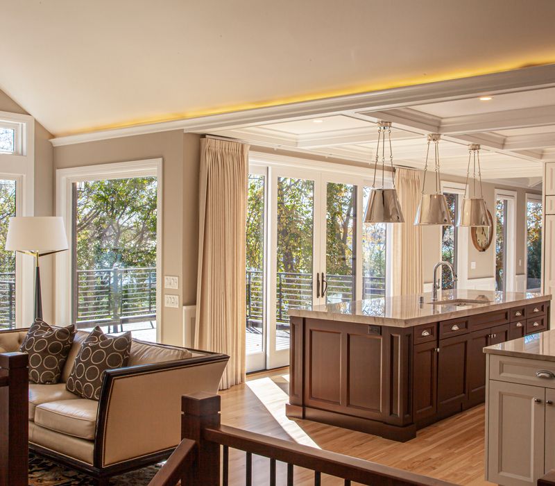 This lakeside brick home has vaulted and coffered ceilings, twin picture windows on either side of a fireplace, hardwood floors, two second-story decks, and a finished basement. 