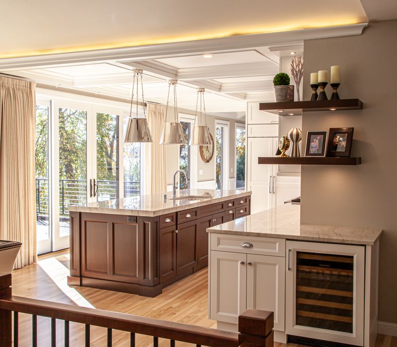 This lakeside brick home has vaulted and coffered ceilings, twin picture windows on either side of a fireplace, hardwood floors, two second-story decks, and a finished basement. 