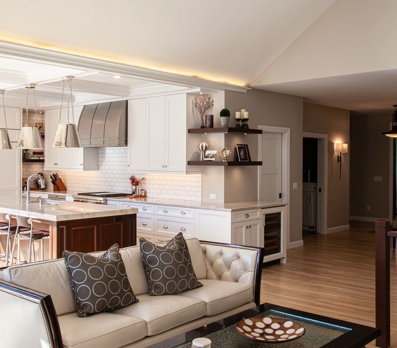 This lakeside brick home has vaulted and coffered ceilings, twin picture windows on either side of a fireplace, hardwood floors, two second-story decks, and a finished basement. 