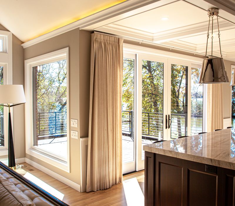 This lakeside brick home has vaulted and coffered ceilings, twin picture windows on either side of a fireplace, hardwood floors, two second-story decks, and a finished basement. 