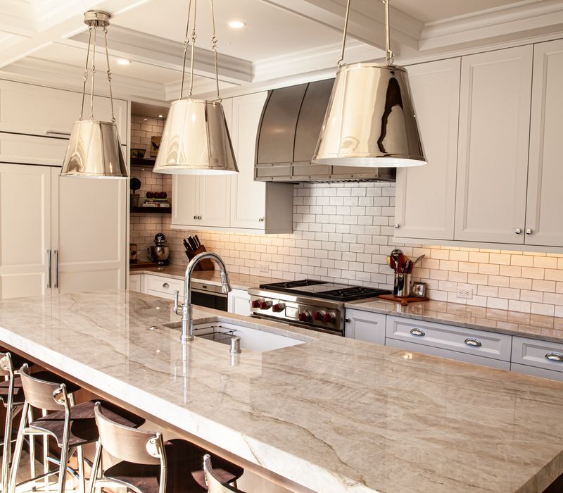 This lakeside brick home has vaulted and coffered ceilings, twin picture windows on either side of a fireplace, hardwood floors, two second-story decks, and a finished basement. 